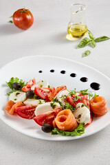 Salmon and mozzarella Caprese salad with fresh tomatoes, top view. Ideal for culinary magazines and healthy eating blogs