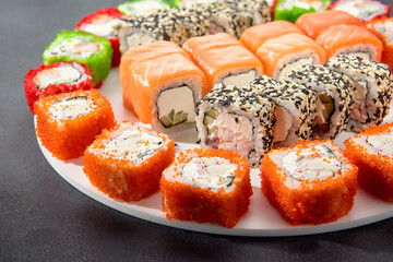 Assorted sushi rolls with salmon, tobiko caviar, and sesame seeds, a feast for sushi enthusiasts