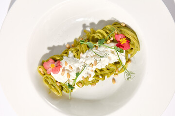 Top View of Spaghetti with Pesto Sauce and Stracciatella Cheese, Artistic Plating on White...