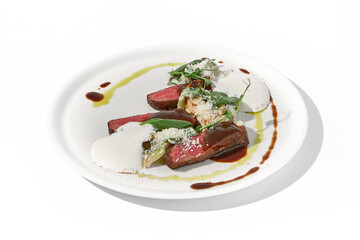 Pan-seared veal cutlet with cheese espuma and Demi-glace sauce on a sophisticated white plate for a refined culinary presentation