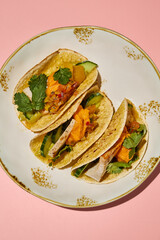 Top view of sweet potato mousse and turkey tacos on a gold-rimmed plate against a pink backdrop