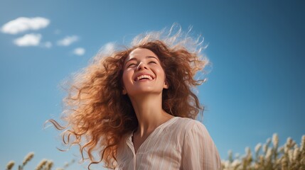 Happy woman with curly hair under blue sky