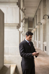 Indian businessman using his Smart phone outdoors.