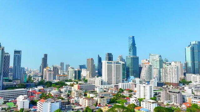 4K - Bangkok Thailand: Drone Aerial view, Over the urban sprawl, the drone hovers, a silent sentinel above towering skyscrapers and high rises, witnessing the heartbeat of the metropolis. 
