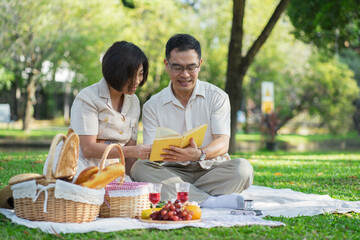 Happy asian middle aged couple in love on a romantic date outdoors in the summer at the park.