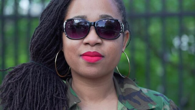 Beautiful Black Woman With Natural Hair Wearing Sunglasses And Red Lipstick Looking Into The Camera And Turning Away.