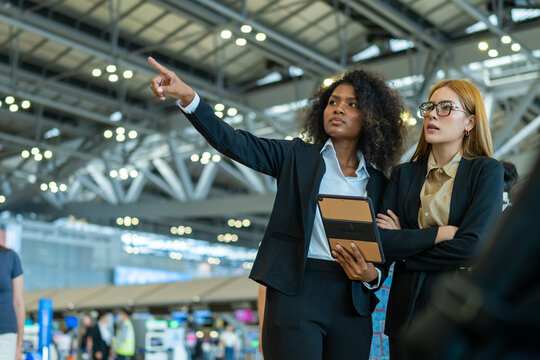 Businesswoman colleague working discussion and using digital tablet for online corporate business during waiting flight check in at airport terminal. Business travel and air transportation concept