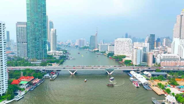 4K - BANGKOK THAILAND: A drone captures the dynamic convergence of high-rises bordering the majestic Chao Phraya River. Iconic landmarks concept. Timelapse. Hyperlapse.
