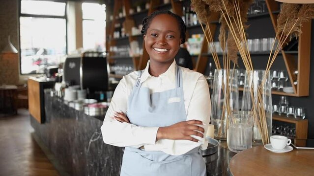Portrait of an African American waitress standing at cafe and smiling