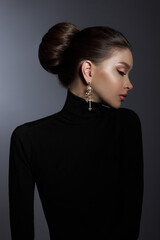 Woman poses confidently, dressed in a stylish black turtleneck and exquisite luxury jewelry. Hair...