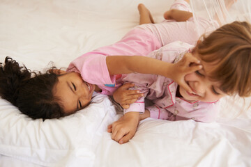 Children, playing and fight on bed on weekend, fun and tickling with laughing on sleepover in home....