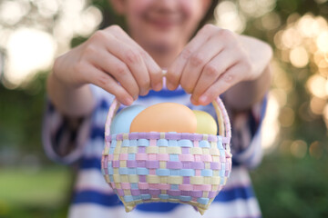 Close up of colorful Easter eggs in a basket on grass in the garden. Happy easter festival...