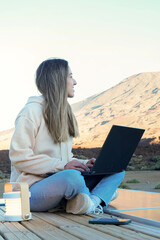 Young Woman Using Laptop on Van Roof in Teide Mountain at Sunset