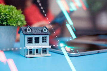 House model on the background of the stock market. The concept of buying a house.Real estate concept