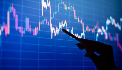 Businesswoman manually drawing a diagram on a touch screen interface. Stock market concept