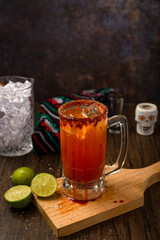 Michelada, typical mexican cocktail on a wooden table. Beer cocktail.