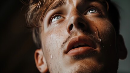 Divine Embrace: Tearful Encounter with Grace. Captivating close-up of a young man touched by the divine. Perfect for conveying faith and emotion.