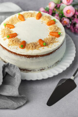 Homemade carrot cake made with walnuts, iced with cream cheese. Sweet dessert.