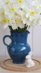garden white daffodils and an Easter bunny figurine on the table in the cottage. Concept: Spring, Easter.