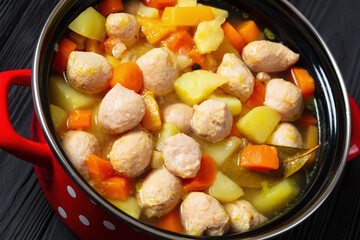 finnish sausage soup with vegetables in red pot
