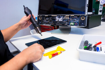 Technician fixing a computer component using a soldering iron