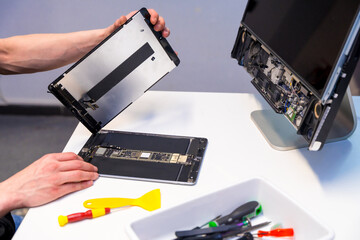 Technician fixing a digital tablet in a workshop