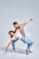 athlete kizomba or bachata or semba or taraxia dancers in casual clothes on rehearsal, training together in studio on bright white background. The grace, artist, movement, action and motion concept.