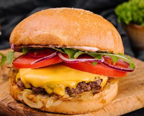 Tasty grilled home made burger with beef, tomato, cheese, onion and lettuce.