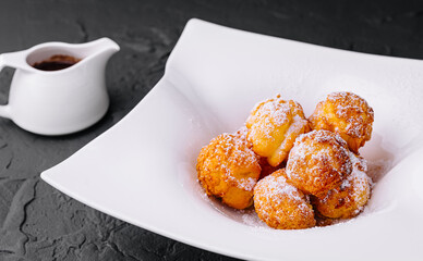Profiteroles with powdered sugar and chocolate cream
