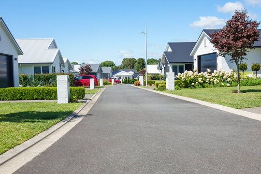 Suburban homes lining new orderly street.