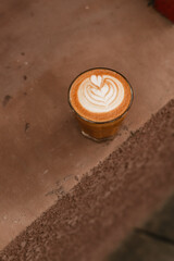 Cappuccino with beautiful latte art in a glass on concrete background