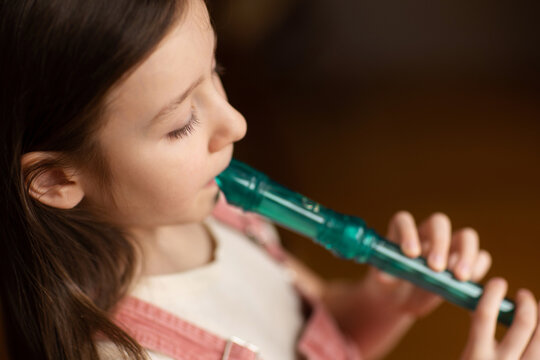 child playing flute. learning to play musical instruments at music school