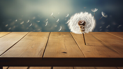 A dandelion blowing in the wind on a table.