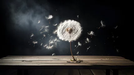  A dandelion blowing in the wind on a table. © Anas