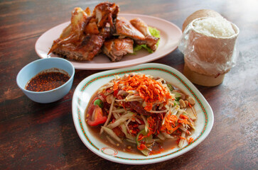 Thai papaya salad and grilled chicken on table