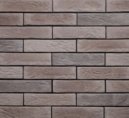 Stone cladding wall made of striped stacked slabs of brown rocks. Panels for exterior. Background and texture.