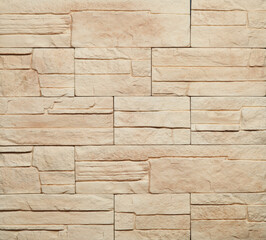 Stone cladding wall made of striped stacked slabs of yellow and brown rocks. Panels for exterior. Background and texture.