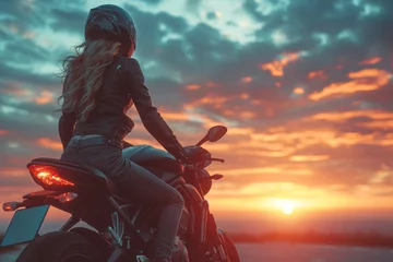 Poster Im Rahmen The silhouette of a stylish young woman on a motorbike at sunset embodies freedom and adventure. © Iryna