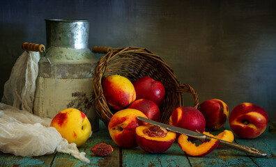 Ripe and juicy nectarines rolled out of the basket onto the table. Knife and cut fruit. Delicious and healthy food.