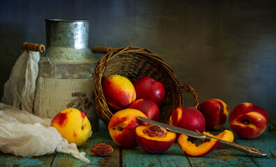 Ripe and juicy nectarines rolled out of the basket onto the table. Knife and cut fruit. Delicious...