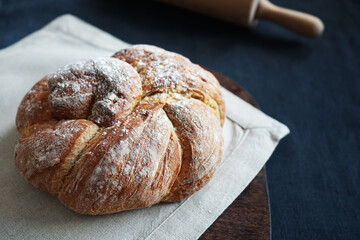 Fresh bread on a linen towel on a dark background