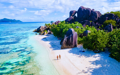 Anse Source d'Argent beach, La Digue Island, Seychelles, Drone aerial view of La Digue Seychelles bird eye view.of tropical Island, couple men and woman walking at the beach during sunset