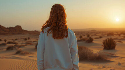 Fototapeta na wymiar Redhead girl in white sweatshirt standing in the desert