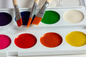 set of paint brushes and colorful paints. On a white background.