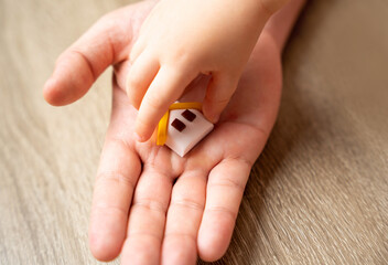A child's hand takes a house from an adult's hand. The concept of transfer of property and...