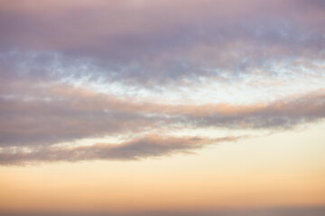 A beautiful sky tinted by the sun leaving vibrant shades of gold, pink, blue and multicolored. Clouds in the twilight evening and morning sky. Cloudy sky background in the evening and during the day.