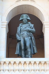 Statue de Napoléon 1er (Napoleon Bonaparte), célèbre empereur français, sous une arcade de la galerie du Midi donnant sur la cour d’honneur de l’Hôtel des Invalides, dans la ville de Paris (France)