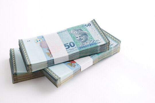 Stack of Ringgit Malaysia bank note on white background. Malaysia Currency Ringgit RM50. Selective focus.