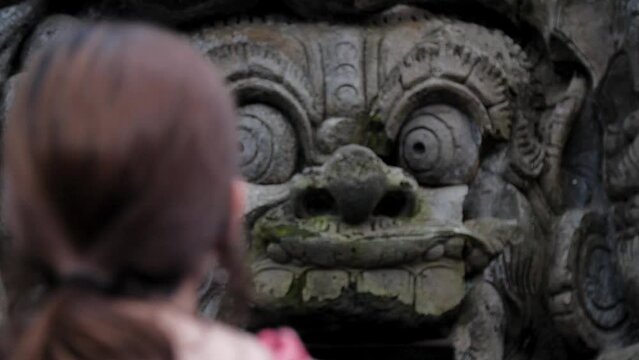 High definition slow motion footage of woman looking at the entrance of elephant cave at Goa Gajah temple in Bali, Indonesia.
Medium angle, focus movement.
