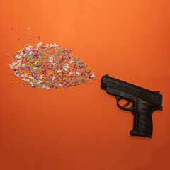 Pistol shooting sprinkles creative concept. Flat lay. 